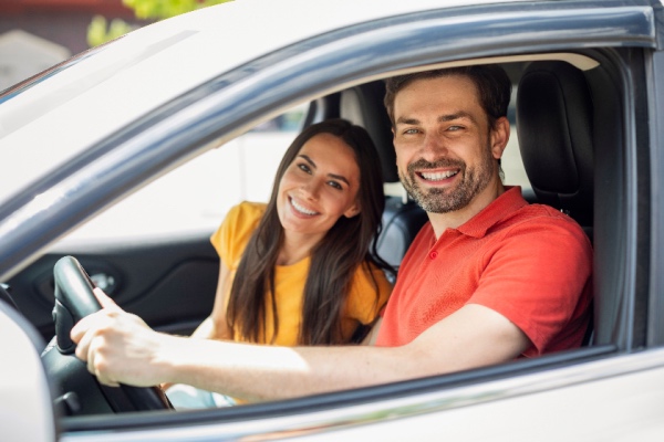 Couple in car smiling at camera